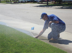 a Missouri City irrigation contractor is checking a sprinkler head